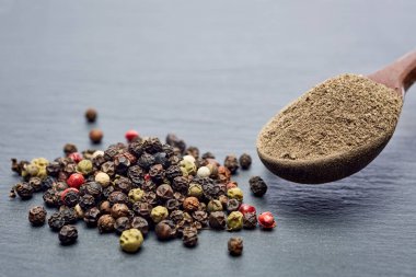 Koyu arka plan üzerine sığ derinlik-in tarla, ön odak izole yenibahar tohumların tam bir tahta kaşıkla Üstten Görünüm