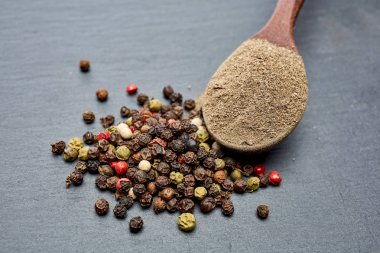 Koyu arka plan üzerine sığ derinlik-in tarla, ön odak izole yenibahar tohumların tam bir tahta kaşıkla Üstten Görünüm