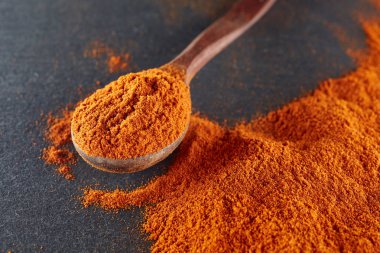 Doku arka plan. Kırmızı biber biber toz tahta kaşıkla karıştırılarak. Üstten Görünüm