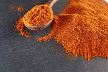 Doku arka plan. Kırmızı biber biber toz tahta kaşıkla karıştırılarak. Üstten Görünüm