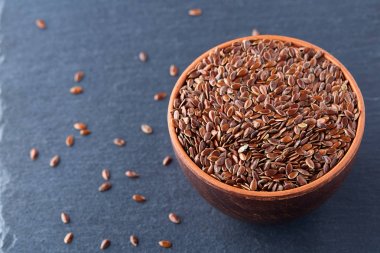 Birçok keten tohumu arka planda dağınık ve kil plaka, metin için yer içine dökülür