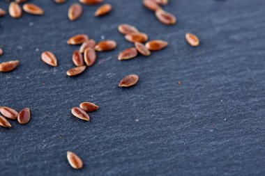 Tahta kaşık siyah taş plaka üzerinde organik keten tohumu kapatın