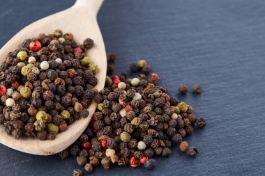 Koyu arka plan üzerine sığ derinlik-in tarla, ön odak izole yenibahar tohumların tam bir tahta kaşıkla Üstten Görünüm