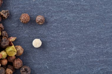 Koyu arka plan üzerine sığ derinlik-in tarla, ön odak izole yenibahar tohumların tam bir tahta kaşıkla Üstten Görünüm