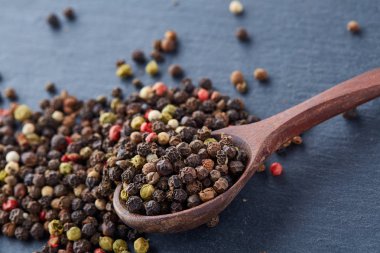 Koyu arka plan üzerine sığ derinlik-in tarla, ön odak izole yenibahar tohumların tam bir tahta kaşıkla Üstten Görünüm