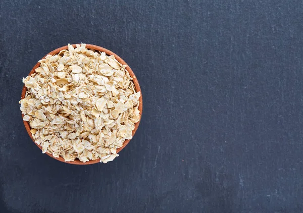 Köşede siyah bir taş zemin üzerine yerleştirilmiş sarı yulaf piramit