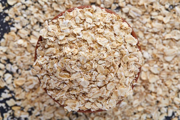 Yellow oats pyramid positioned in the corner on a black stone background — Stock Photo, Image