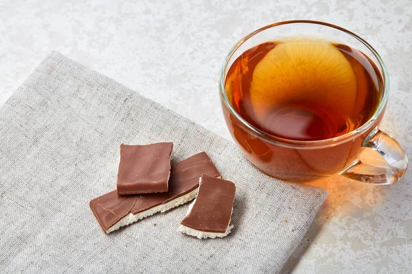 Top view close up picture of tea in glass cup with chocolate isolated on white background, vertical — Stock Photo, Image