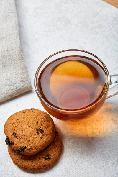 Vista superior de cerca imagen de taza de té de vidrio con galletas aisladas sobre fondo blanco, enfoque frontal, profundidad de campo poco profunda — Foto de Stock