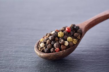 Çince biber, tahta kaşık siyah arduvaz taş plaka üzerinde Sichuan biber