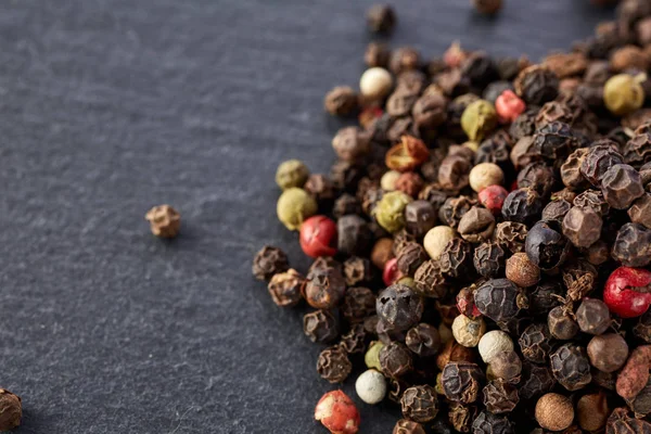 Bulk van diverse peper peper zaden mix op donkere steen — Stockfoto