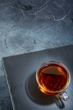 Siyah çay koyu grimsi mermer zemin, dikey bir cam bardak. Kahvaltı arka plan