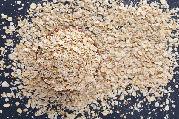 Top view selective focus picture of pile of oatmeal on dark background. — Stock Photo, Image