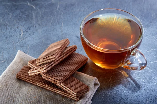 A glass cup of black tea with waffles on a dark greyish marble background, selective focus. Breakfast background — Stock Photo, Image