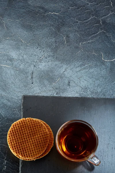 Siyah çay ile waffle koyu grimsi mermer zemin, dikey bir cam bardak. Kahvaltı arka plan