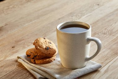 Rustik ahşap arka plan, üstten görünüm peçeteye pamuk üzerinde çerezleri porselen çay fincanı çikolata ile cips