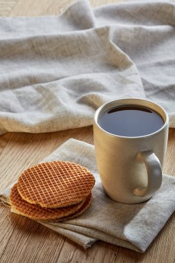 Pamuk peçeteye bir rustik ahşap arka plan, üstten görünüm, dikey olarak waffle ile porselen çay fincanı