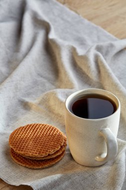 Pamuk peçeteye bir rustik ahşap arka plan, üstten görünüm, dikey olarak waffle ile porselen çay fincanı