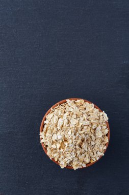 Bir tabak yulaf ezmesi koyu arka plan üzerinde izole üstten görünüm resmi yakın çekim.