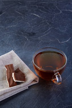 Cam bardak koyu grimsi mermer zemin üzerine çikolata parçaları ile siyah çay. Üstten Görünüm