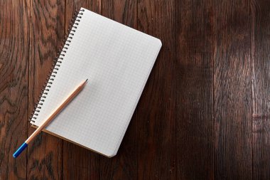 Beyaz kalem çam kahverengi ahşap tahta üzerinde defterini kontrol ettim