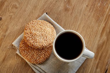 Rustik ahşap arka plan, üstten görünüm peçeteye pamuk üzerinde çerezleri porselen çay fincanı çikolata ile cips