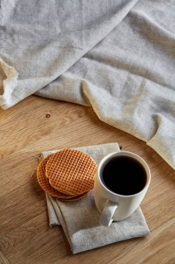 Pamuk peçeteye bir rustik ahşap arka plan, üstten görünüm, dikey olarak waffle ile porselen çay fincanı