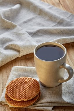 Pamuk peçeteye bir rustik ahşap arka plan, üstten görünüm, dikey olarak waffle ile porselen çay fincanı