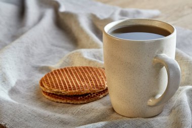 Pamuk peçeteye bir rustik ahşap arka plan, üstten görünüm, dikey olarak waffle ile porselen çay fincanı
