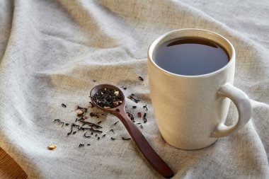 Rustik ahşap arka plan, seçici odak bir peçeteye dağınık çay yapraklar ile fincan seramik