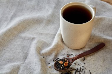 Rustik ahşap arka plan, seçici odak bir peçeteye dağınık çay yapraklar ile fincan seramik