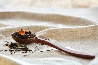 Bir tahta kaşık closeup dağınık çay yaprakları ile sığ derinlik-in tarla, üstten görünüm dolu.