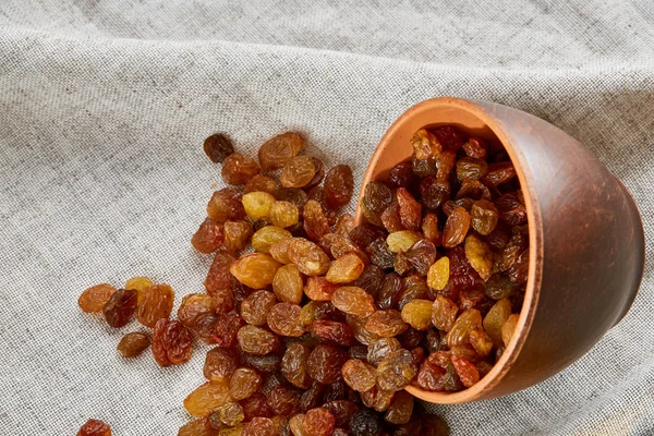 Bol en céramique avec raisins secs dorés sur une nappe légère, gros plan, mise au point sélective — Photo