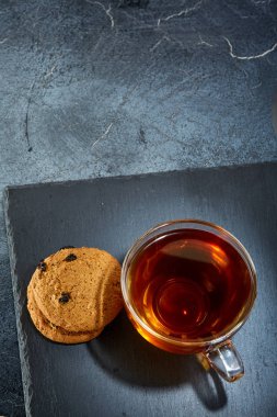 Siyah çay kek koyu grimsi mermer zemin ile cam fincan fotoğrafın alan sığ derinliği.