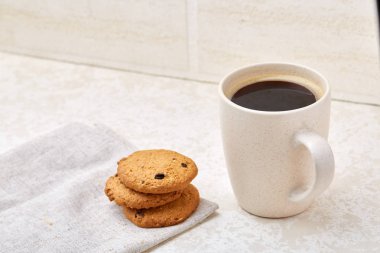 Yakın çekim beyaz fincan kahve ile çikolatalı kurabiye beyaz arka planda, üstten görünüm