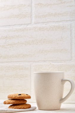 Yakın çekim beyaz fincan kahve ile çikolatalı kurabiye beyaz arka planda, üstten görünüm