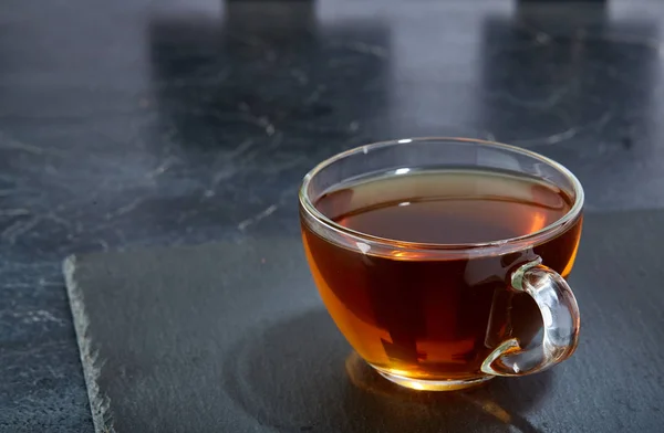 Glas kopp te isolerad på mörk marmor bakgrund, närbild — Stockfoto