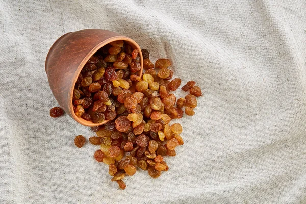 Taça de cerâmica com passas douradas em toalha de mesa leve, close-up, foco seletivo — Fotografia de Stock