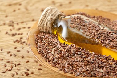 Üstten Görünüm portre resim keten tohumu ve ahşap zemin, sığ derinlik-in tarla bir cam şişe keten tohumu yağı.