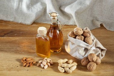 Cam petrol kavramsal kompozisyon kavanozlar ahşap masa, fındık çeşitleri ile yakın çekim.