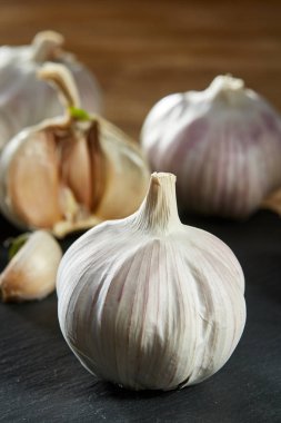 Sarımsak yakın çekim rustik arka plan, sığ derinliği alan, seçici odak, makro, dikey olarak ahşap plaka üzerinde.
