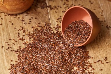 Linseeds bir rustik arka plan, yakın çekim, sığ derinlik-in tarla, seçici odak ile devrilmiş bir seramik kase