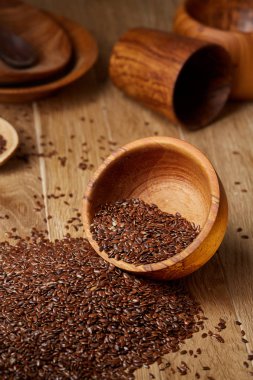 Linseeds bir rustik arka plan, yakın çekim, sığ alan, seçici odak derinliği ile devrilmiş bir ahşap kase