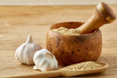 Ahşap harç ve havaneli ile sarımsak ve eziyet baharat rustik masa, yakın çekim, seçici odak