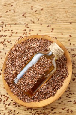 Üstten Görünüm portre resim keten tohumu ve ahşap zemin, sığ derinlik-in tarla bir cam şişe keten tohumu yağı.