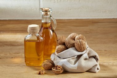 Aromatik yağ bir cam kavanoz ve şişe ahşap masa, yakın çekim, dikey kase fıstık ile