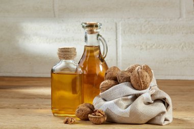 Aromatik yağ bir cam kavanoz ve şişe ahşap masa, yakın çekim, dikey kase fıstık ile