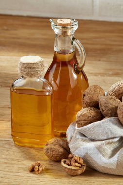 Aromatik yağ bir cam kavanoz ve şişe ahşap masa, yakın çekim, dikey kase fıstık ile