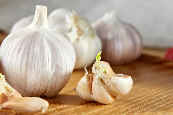 Knoflook close-up op houten plaat op rustieke achtergrond, ondiepe diepte van veld, selectieve aandacht, macro — Stockfoto