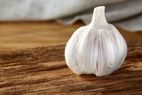 Sarımsak yakın çekim rustik arka plan, sığ derinliği alan, seçici odak, makro üzerinde ahşap plaka üzerinde — Stok fotoğraf